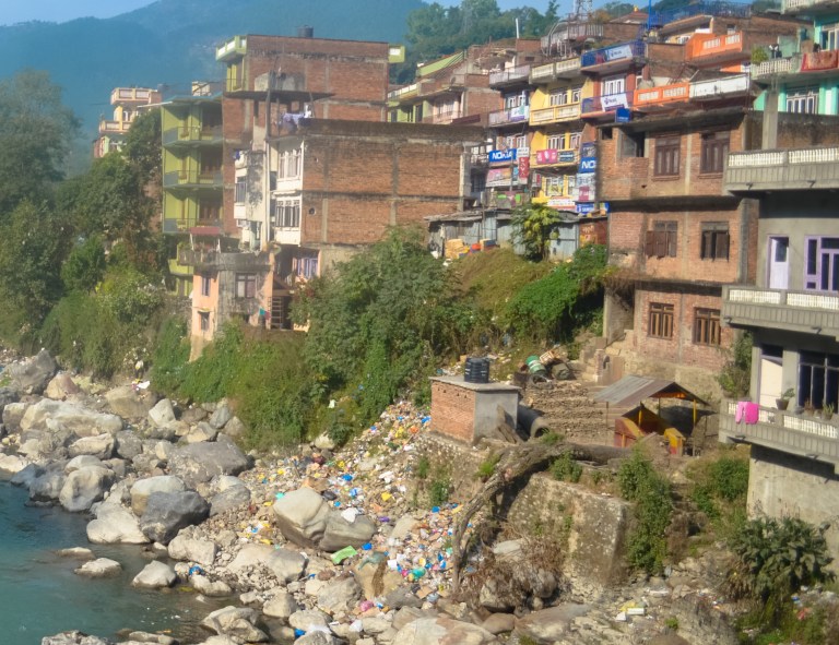 Plastic bags and garbage line the banks of the Tirsuli River.